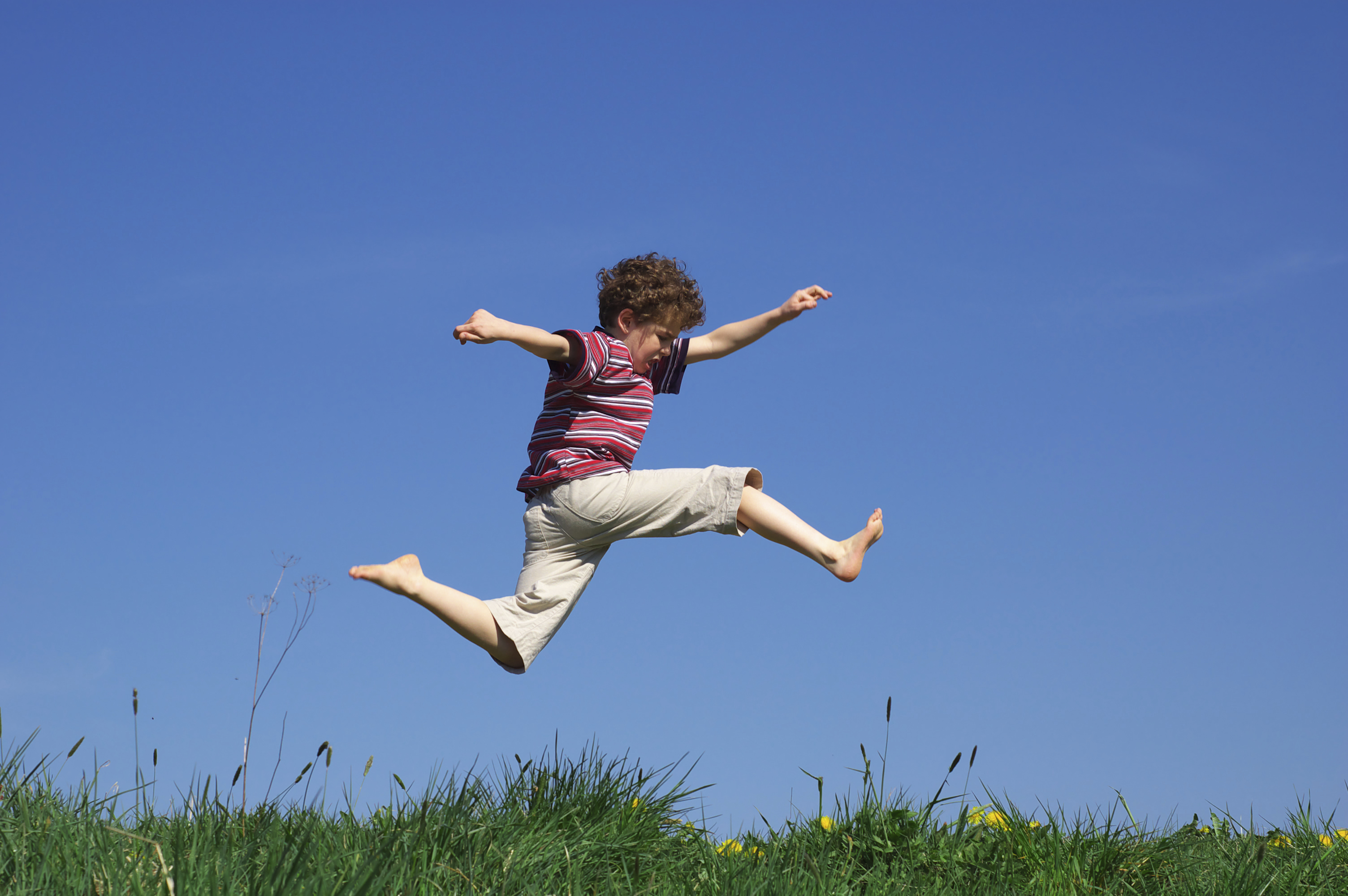 child-leaping-through-meadow